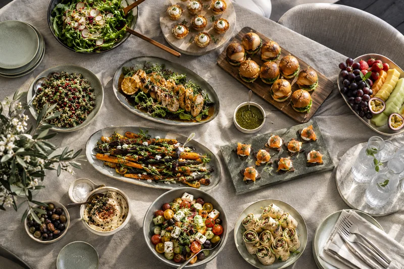 An overhead view of shared dishes, salads and savoury bites