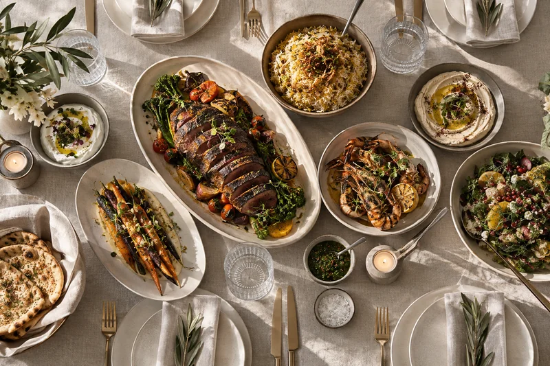 A dinner spread with sliced roast beef, rice, chicken and vegetables