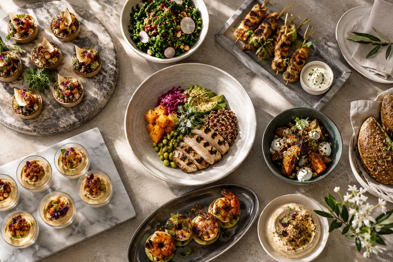 An overhead catering selection with chicken, vegetables and savoury tartlets