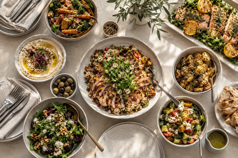 An overhead lunch spread with grilled chicken, fish, vegetables and salads
