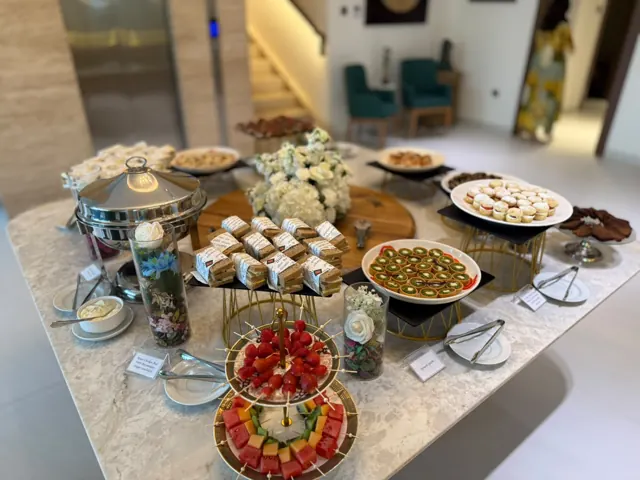 Afternoon tea spread with savouries, sweets and fresh flowers.
