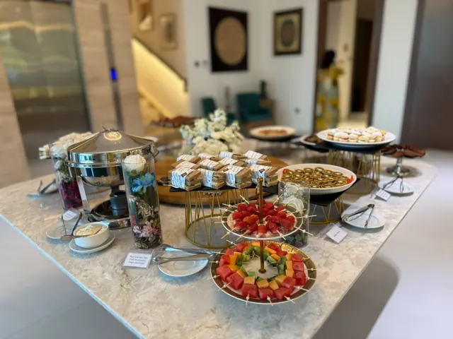 Afternoon tea table with tiered stands, pastries and fruit.