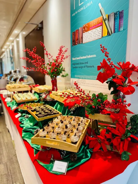 Angled view of a Christmas buffet with garlands and bite-sized dishes.