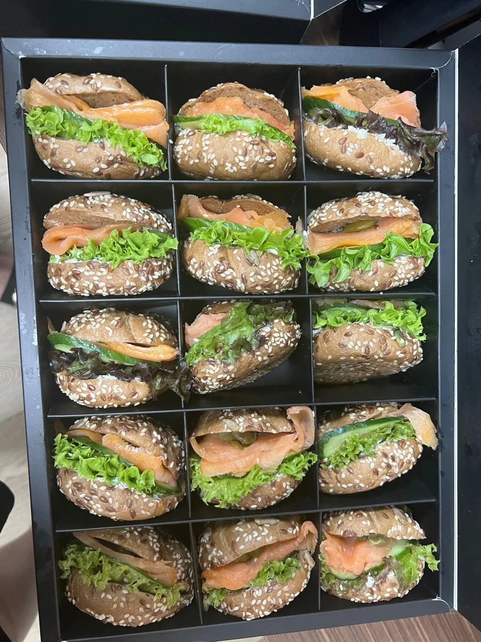 Boxed miniature sandwiches and savoury rolls.