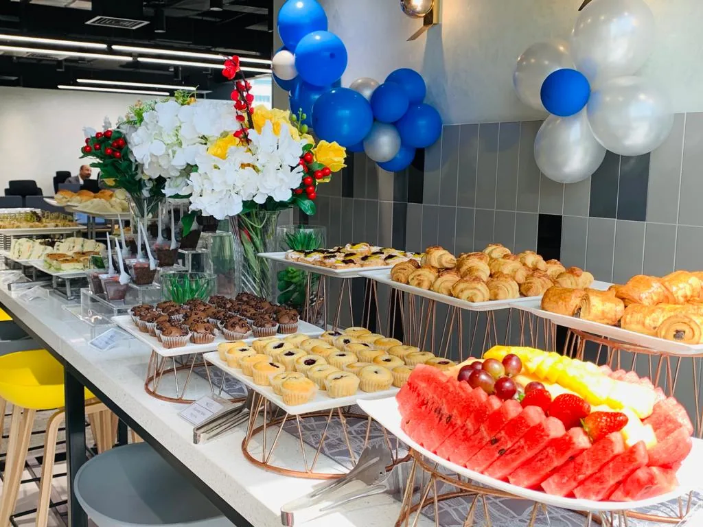 Breakfast buffet with pastries, fruit and balloon decorations.