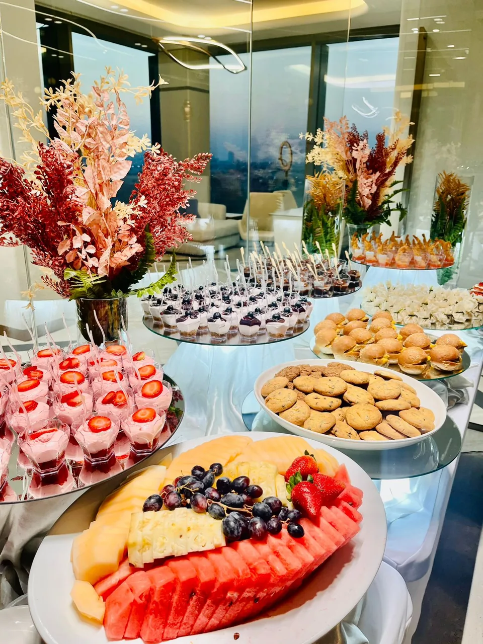 Breakfast sweets and sliced fruit on a styled buffet table.