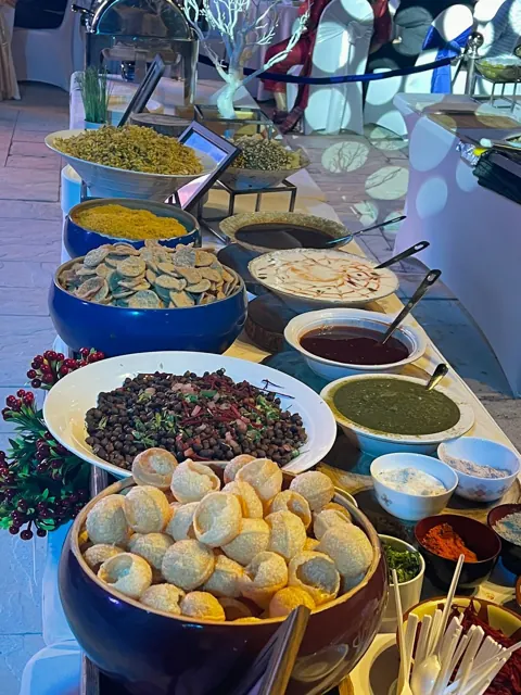 Chaat counter with crisp shells, toppings and dipping sauces.