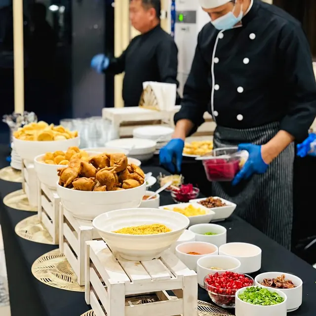 Chefs serving savoury bites from a live chaat counter.
