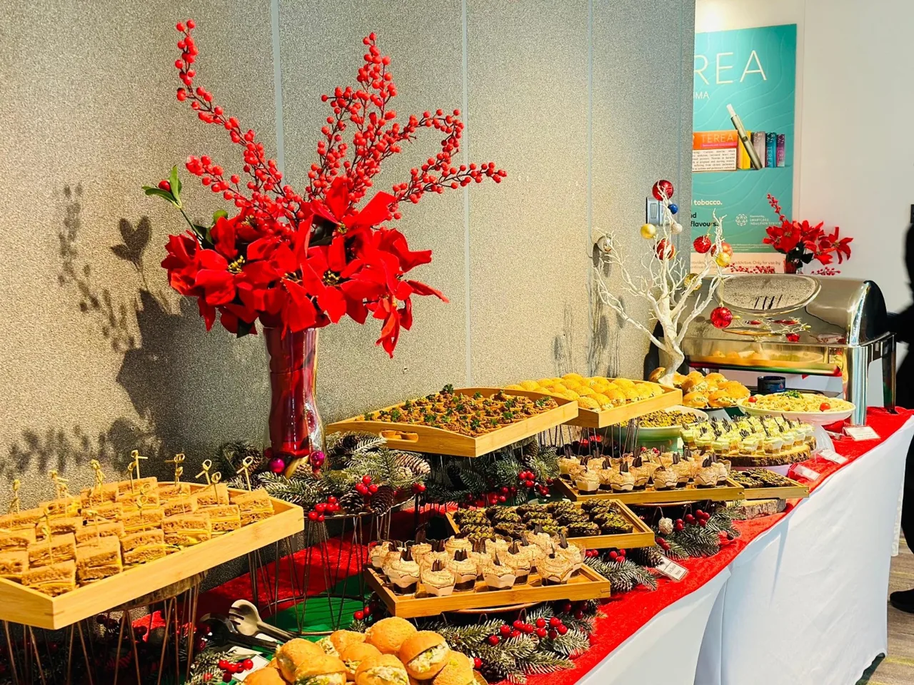 Christmas buffet with red floral arrangements and festive food displays.