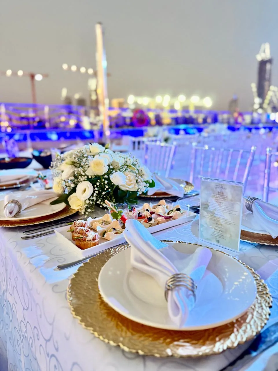 Close view of a white and gold place setting on a yacht deck.