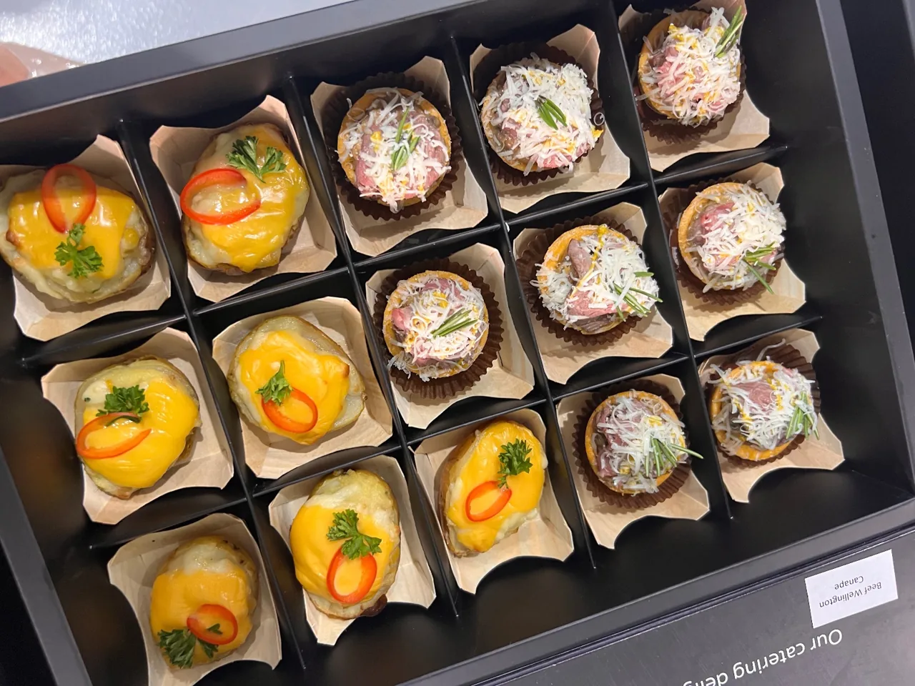 Close view of savoury canapés in individual presentation compartments.