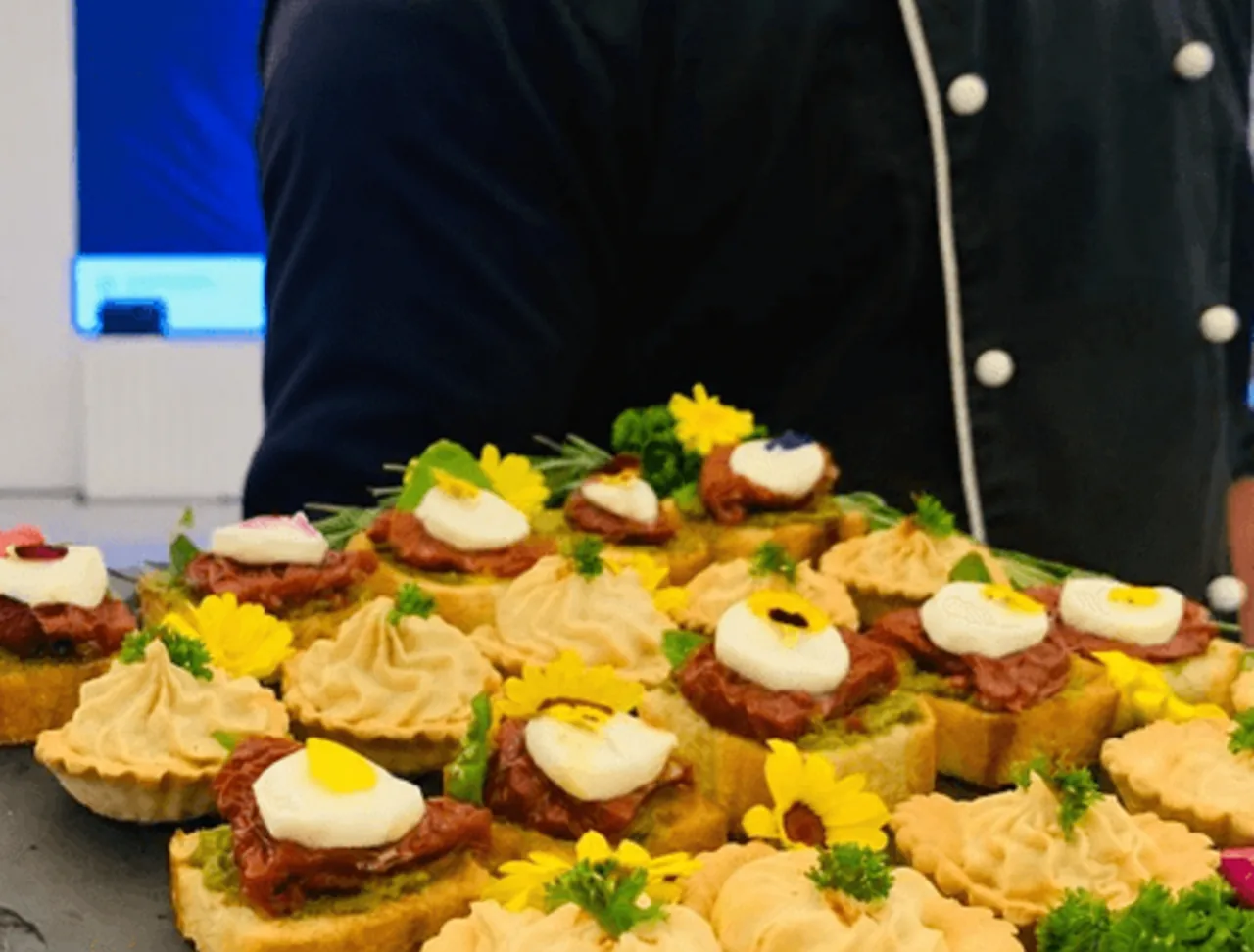 Close view of savoury canapés topped with cream and herbs.