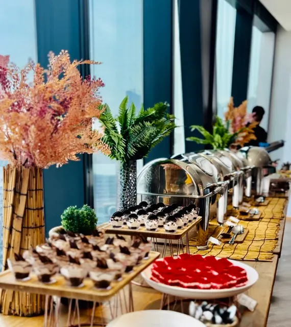 Dessert buffet with bite-sized sweets, fruit and floral arrangements.