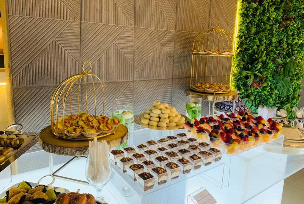 Dessert display with miniature sweets, fruit and gold stands.