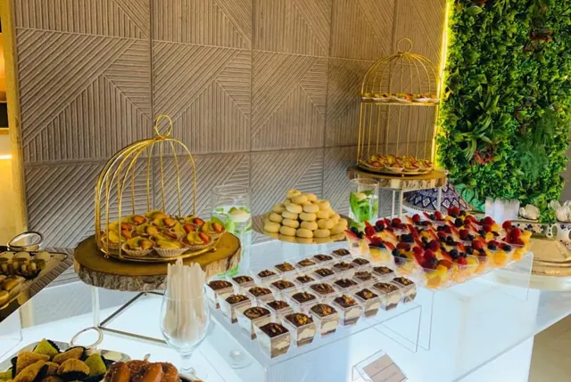 Dessert display with miniature sweets, fruit and gold stands.