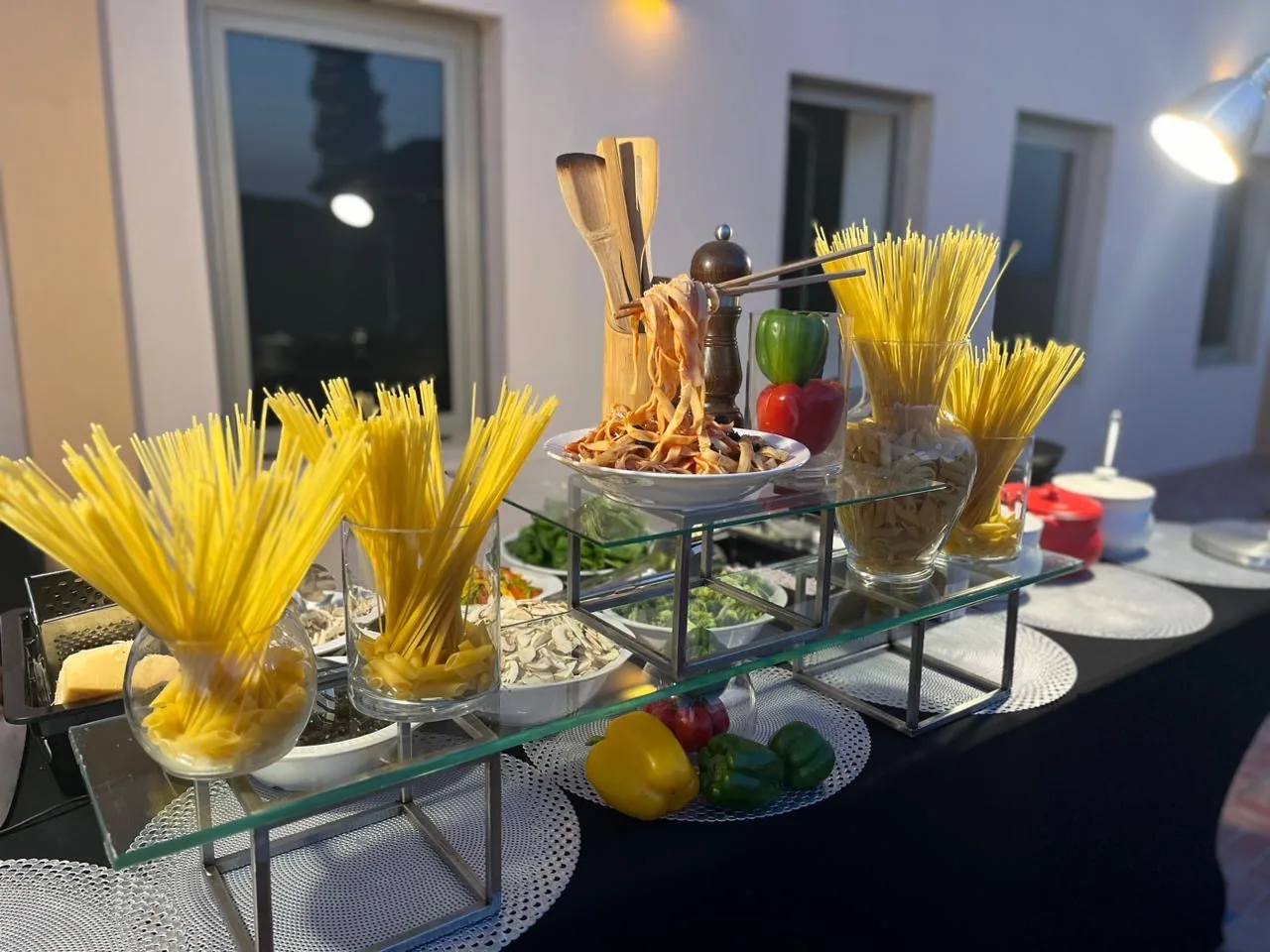 Live pasta counter with glass stands and sauce ingredients.