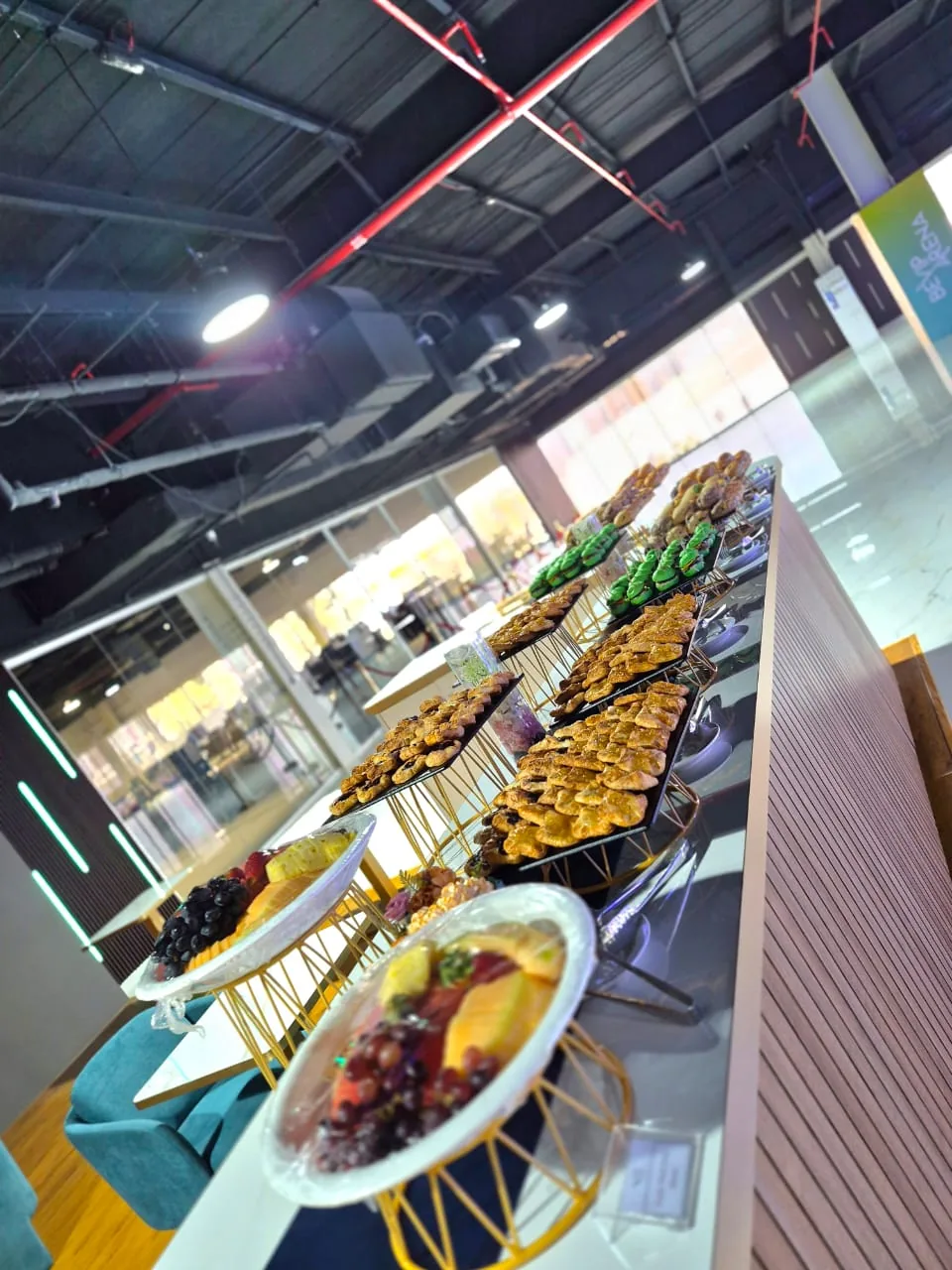 Long buffet with salads and warm dishes in an event space.