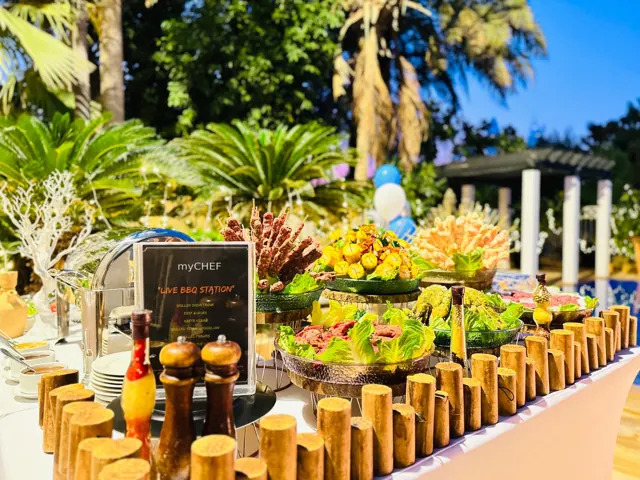 Outdoor skewer buffet with vegetables and a myCHEF station sign.