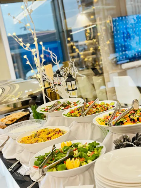 Ramadan buffet with salads, warm dishes and serving bowls.