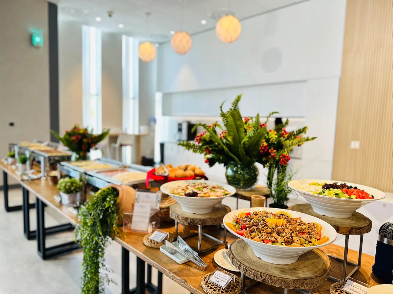 Salad buffet with colourful bowls and a floral centrepiece.