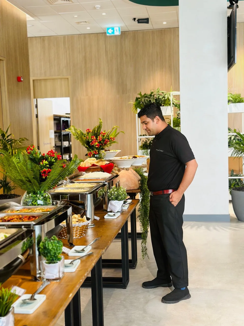 Service staff preparing a long catered buffet indoors.