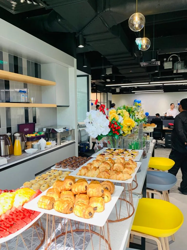 Wide view of a breakfast buffet with pastries and juices.